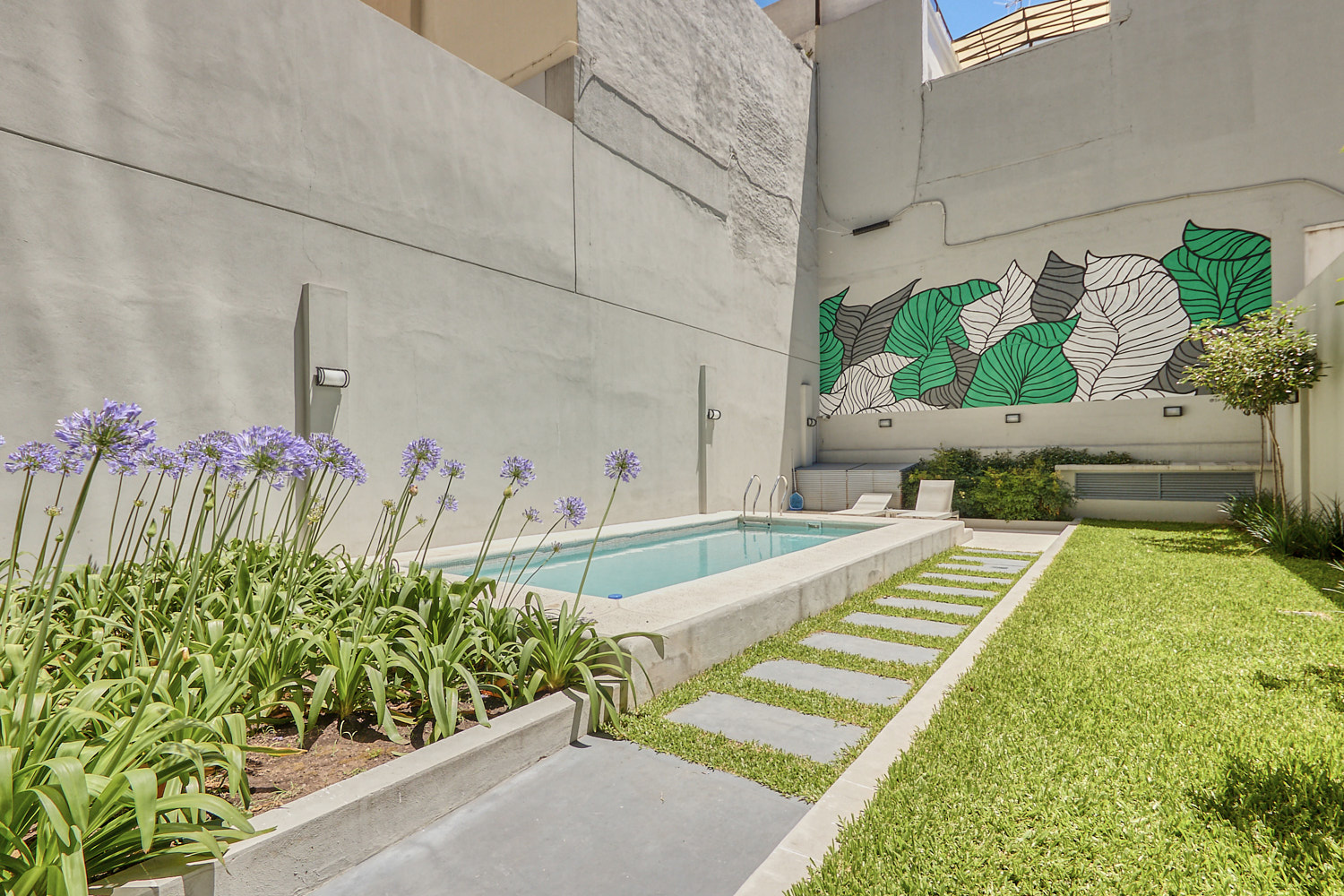 Pileta con jardín y mural